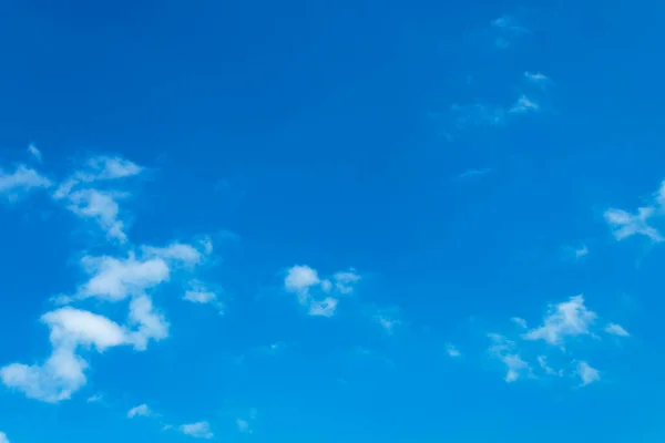 Beyaz bulutlar açık mavi gökyüzüne karşı.