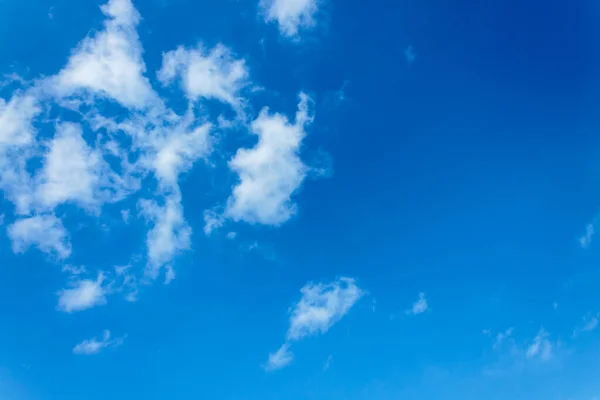 Beyaz bulutlar açık mavi gökyüzüne karşı.