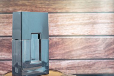 Koyu ahşap arka planda erkek parfümü şişesi..