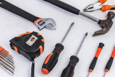 Üstten bakıldığında beyaz arka planda duran, inşaat ve onarım için bir takım araçlar.