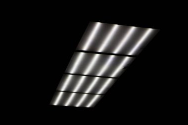 Tavanda flüoresan lambalar var. Tepesinde lambalar olan panel.