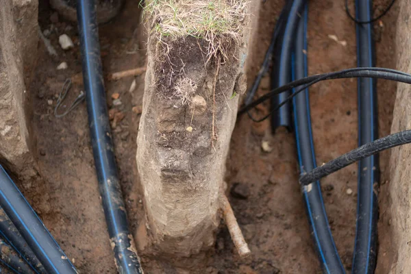 A kábel a földbe van fektetve. Leteszem az elektromos kábelt a földbe. Városi kommunikáció. — Stock Fotó