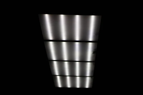 Fluorescent lamps on the ceiling. Panel with lamps at the top.