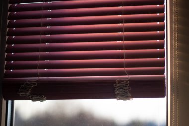 Pencere perdeleri. Kırmızı panjurlar pencereyi güneş ışığından koruyor.