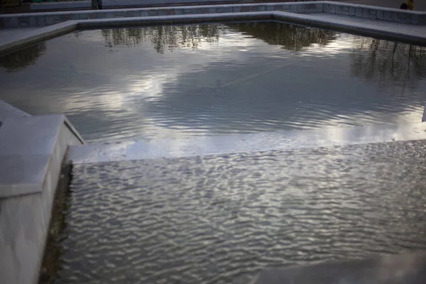 Reservatório artificial no parque. Água na fonte. Superfície de água em uma piscina de pedra. — Fotografia de Stock