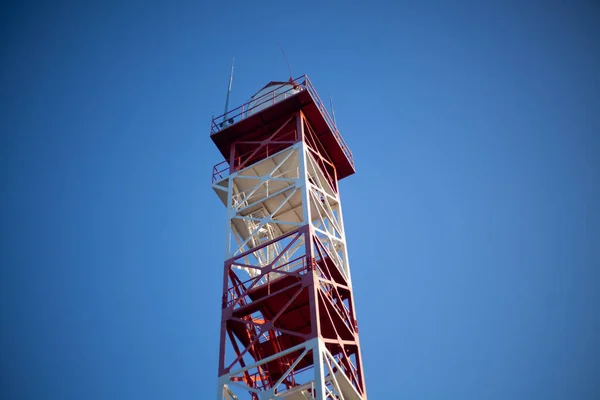 Telephone tower. Radio. The tall tower is red and white. Signal transmission device. View of the tower from below. — Stock Photo, Image