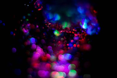 Renkli su dokusu. Farklı renklerde yanan su damlaları. Çeşmeden yakın plan su çekimi. Parlak renkler su akış arkaplanı.