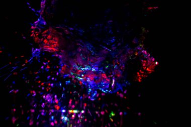 Renkli su dokusu. Farklı renklerde yanan su damlaları. Çeşmeden yakın plan su çekimi. Parlak renkler su akış arkaplanı.