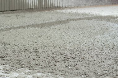 Liquid cement at a construction site. Cement spilled onto the road. The building material is cement and gravel.