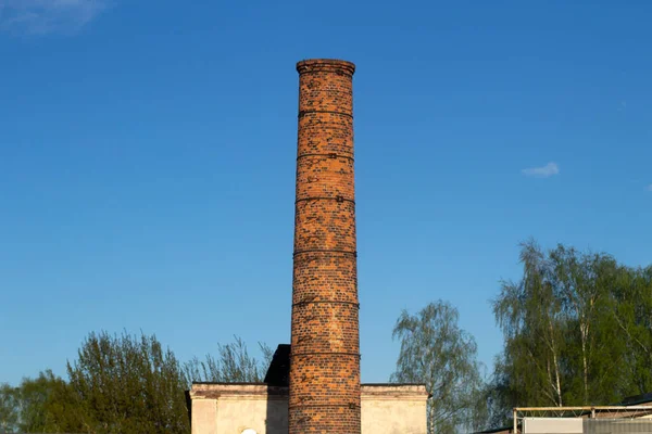 Factory brick pipe. A brick chimney rises against the sky. Old factory in the city.