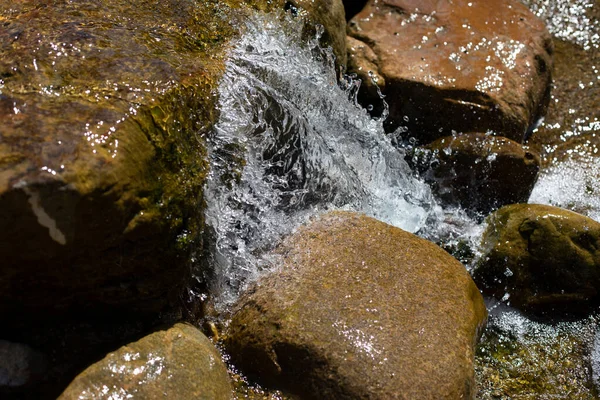 一条山溪倾泻在石头上 河流中的瀑布 溪流上的急流石头被水湿透了 瀑布的美丽背景 — 图库照片