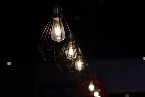 Havalı lambalar karanlıkta asılı. Lambalar yanıyor. Kafede bir sıra lamba..