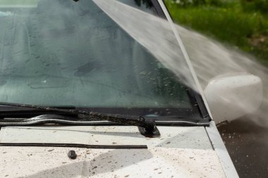 Ön camı çamurdan temizliyorum. Araba duvarların basıncıyla yıkanır. Çamurlu bir yoldan sonra araçlarla ilgilenmek.