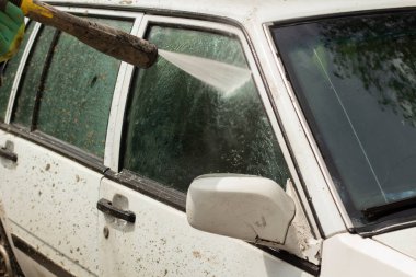 Araba yıkamada yıkanır. Arabayı çamurdan yıkıyorum. Araba yıkamak için yüksek basınçlı su püskürtme ekipmanı.