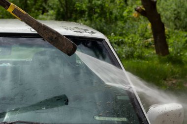 Ön camı çamurdan temizliyorum. Araba duvarların basıncıyla yıkanır. Çamurlu bir yoldan sonra araçlarla ilgilenmek.