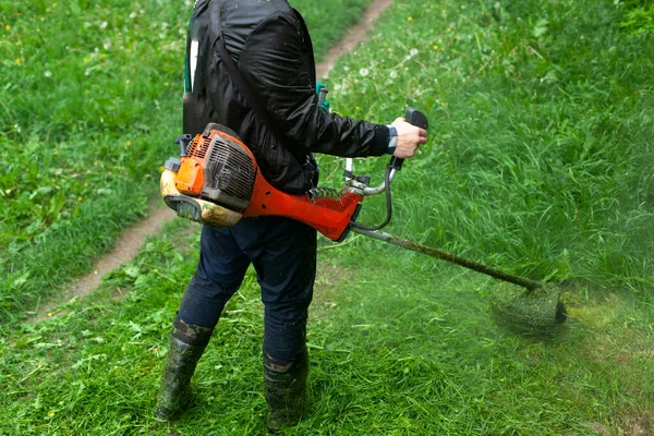 Κουρεύει Γρασίδι Μια Φορητή Χορτοκοπτική Μηχανή Κηπουρός Κόβει Γκαζόν Εργαλείο — Φωτογραφία Αρχείου