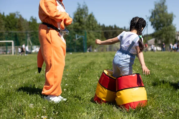 穿着充气靴的孩子庄园主在宴会上表演 有趣的步行靴 给孩子穿上不舒服的鞋子 青草地上的幼稚园游戏 — 图库照片