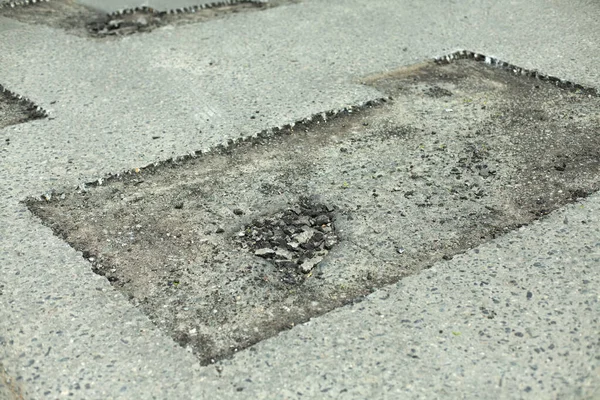 Road repair. Removing holes in the road. A cut piece of asphalt. Fragment of the track being repaired. Highway patching.