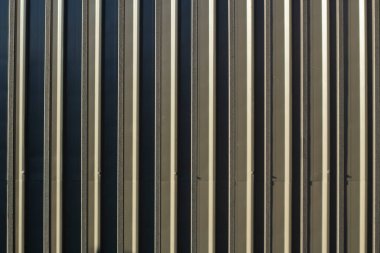 Çit dokusu. Tırtıklı metal bir yapıya yakın çekim. Metal çit. Yatay çizgiler tekrarlanıyor.