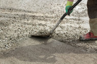 Kumlu kürek. Kürekle kum fırlatıyor. İnşaat alanında çalışıyorum. Yoldaki toprağı temizliyorum..