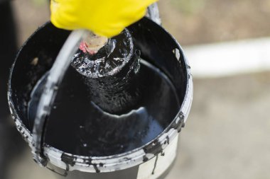 Kovadaki boya fırçası. Ahşap için siyah boya. Su bazlı kalın bir boya tabakasını fırçala.