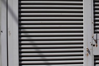 Kafes yapısı. Satır arkaplanı. Güç jeneratörlerinin korunması ve havalandırılması için metal kepenkler. Düz çizgi. Flapların dizisi.