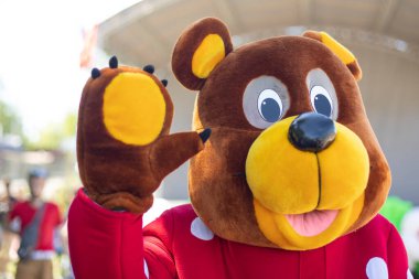 Ayı kostümü giymiş bir animatör. Tatil için uzun boylu takım elbiseli bir adam. Rus ayısı tatilde..