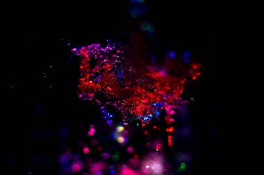 Renkli su dokusu. Farklı renklerde yanan su damlaları. Çeşmeden yakın plan su çekimi. Parlak renkler su akış arkaplanı.