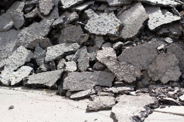 Kırık asfalt. Asfalt yolun parçaları. Kırık yol yüzeyi dokusu. Çatlak asfalt yığını. Otobanın sökülmesi.