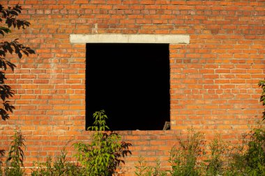 Tuğla duvardaki siyah pencere. Terk edilmiş bina. Bilinmeyen konum. İçerisi karanlık..
