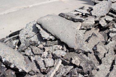 Kırık asfalt. Asfalt yolun parçaları. Kırık yol yüzeyi dokusu. Çatlak asfalt yığını. Otobanın sökülmesi.