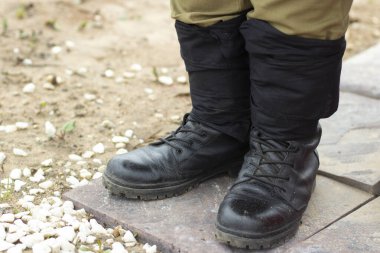 Askeri botlar. Asker botları. Ayak bileği çizmeleri bacaklarda..