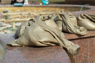 Bir çuval çimento. Çadır bezi torbasında inşaat için çözüm. Parkta granitle yüzleşmek.