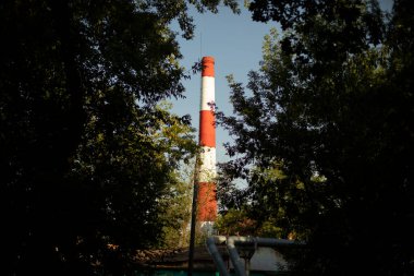 Kazan istasyonunun endüstriyel borusu. Şehrin kırmızı ve beyaz bacası. Buhar çıkarmak için tuğla boru..