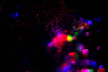 Renkli su dokusu. Farklı renklerde yanan su damlaları. Çeşmeden yakın plan su çekimi. Parlak renkler su akış arkaplanı.