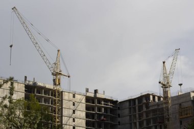 İnşaat vinci olan bir ev inşa etmek. Bir apartman inşaatı. Çok katlı bir binanın görüntüsü.