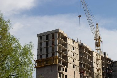 İnşaat vinci olan bir ev inşa etmek. Bir apartman inşaatı. Çok katlı bir binanın görüntüsü.