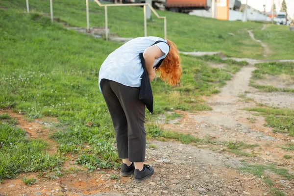 Kız yerdeki bir şeye bakmak için eğildi. Kız küçük bir şey düşürdü. Kadın giysilerinde pislik arıyor..