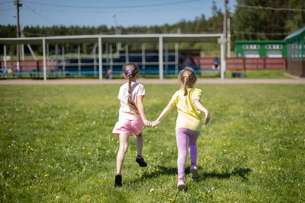 孩子们牵着手跑了 孩子们在草坪上奔跑 女孩子们都赶着去度假 夏天的儿童节 — 图库照片