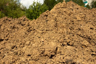 Toprağı kazıp çıkardık. Toprak inşaatı. İnşaat alanında bir çöp yığını. Yığılmış kil.