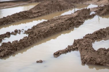 İnşaat alanında kir. Kirli yol. Fırtınadan sonra off-road. Su birikintileri ve çamur.