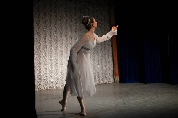 The girl dances in a classic dance dress. The performance of a young ballerina. The artist shows a scene with a dance.