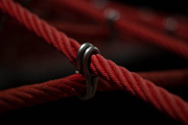 Oyun parkındaki ipler. Tırmanma ağı, yakın çekim. Halatlar halatlarla bağlandı. Gece sokak ışıklarında ip desenli çekim.