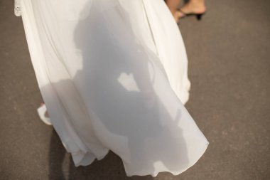Beyaz elbisenin kenarı. Gelinin elbisesindeki gölge. Beyaz kumaş kızın üzerinde..