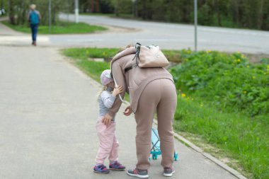 Anne çocuğu büyütür. Annem kızına ne istediğini soruyor. Çocuklarla aile yürüyüşü.