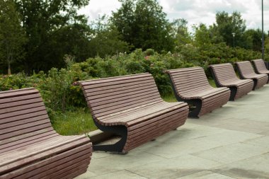 Park bankları. Sokaktaki vatandaşlar için dinlenme yeri. Şehirdeki ahşap banklar. Şehir parkındaki mobilyalar..