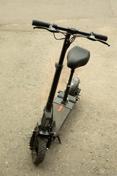 Asfaltta elektrikli scooter. Scooter caddede duruyor. Şehirde elektrik taşımacılığı.