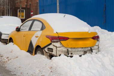Taksiler kışın yol kenarına park edilir. Karla kaplı arabalar. Benzer arabalar arka arkaya park edilmiş. Güzel bir otoparkta nakliye. Terk edilmiş araba paylaşımı.