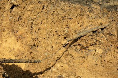 Toprağa borular döşüyorlar. İnşaat sırasında kazılmış toprak. Ağır makinelerin çalışmasının sonucu. Arazi, yeraltı tesislerinin kurulması için hazırlandı..