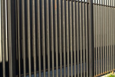 Çit dokusu. Tırtıklı metal bir yapıya yakın çekim. Metal çit. Yatay çizgiler tekrarlanıyor.